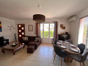 a living room with a table and a couch at Villa 6 personnes 100 m plage 6GSA163 in Le Barcarès