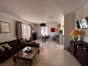 a living room with a couch and a table at Villa 6 personnes 100 m plage 6GSA163 in Le Barcarès