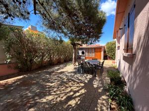 a patio with a table and chairs next to a building at Villa 6 personnes 100 m plage 6GSA163 in Le Barcarès