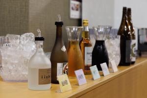 eine Theke mit Flaschen Wein und Gläsern darauf in der Unterkunft Okutamaji in Ome