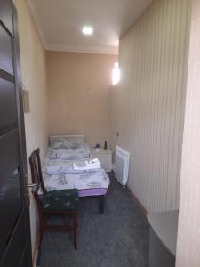 a small bedroom with a bed and a chair at CTH-Baku-Hostel in Baku