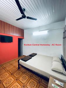 um quarto com uma cama e uma ventoinha de tecto em Konkan Central Kankavali - Budget Home Stay em Kankauli