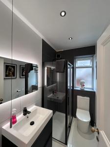 La salle de bains est pourvue d'un lavabo blanc et de toilettes. dans l'établissement Aylestone View, à Hereford