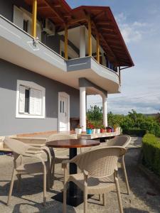 a patio with tables and chairs and a balcony at Rent Rooms Sakolli in Berat
