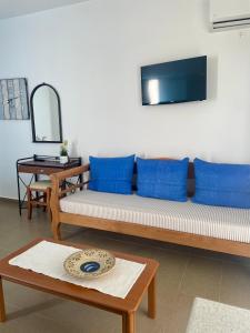 sala de estar con almohadas azules y sofá en Dimora Miranda, en Agios Prokopios
