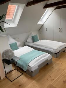 a room with two beds and a table and a window at Nicolai Suite - Schrangen-Suites-1389 in Lüneburg