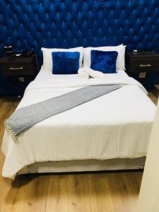 um quarto com uma cama grande e uma cabeceira azul em Naldorado Executive Villa em Nelspruit