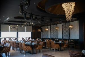 una sala da pranzo con tavoli, sedie e lampadari a braccio di Ankawa Holiday Hotel a Erbil