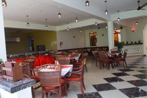 White Peacock Resort في Tezo: غرفة طعام مع طاولات وكراسي في مطعم