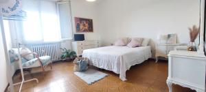 Un dormitorio con una cama y una silla y una ventana. en Dalla Torre al mare, en Cervia 21 fotos más
