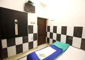a room with a checkerboard wall and a bed at Hotel Gulshan E Razia Manzil in Ajmer