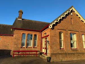 a brick building with a red bench in front of it at Langwathby Station 3 bedroom cottage in Langwathby