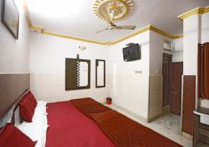 a room with a ceiling fan and a red rug at Hotel Gulshan E Razia Manzil in Ajmer