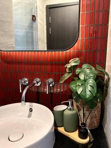 a bathroom with a sink and a mirror and a plant at EDGE Cozy Vacation Condo infinite SKY Pool in Pattaya Central