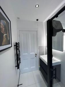 La salle de bains est pourvue d'un lavabo et d'une porte blancs. dans l'établissement Aylestone View, à Hereford
