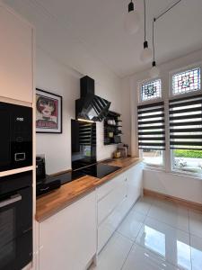 une cuisine avec des armoires blanches et des appareils noirs dans l'établissement Aylestone View, à Hereford
