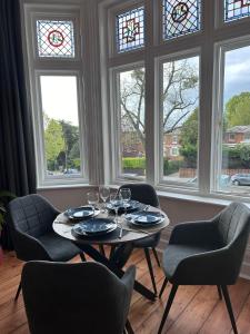 - une salle à manger avec une table, des chaises et des fenêtres dans l'établissement Aylestone View, à Hereford