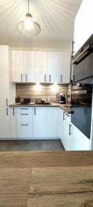 a kitchen with white cabinets and a sink at Les Géraniums, bel appartement rénové, proche plage et commerces in La Seyne-sur-Mer