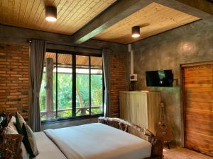 a bedroom with a bed and a guitar in a room at Wooden House Krabi Town in Ban Khlong Chi Lat