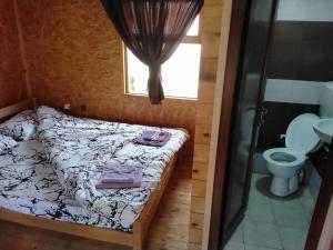 a small bedroom with a bed and a toilet at Etno meandri Uvca in Sjenica