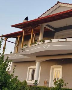 a house with a balcony on the side of it at Rent Rooms Sakolli in Berat