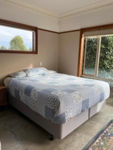 1 dormitorio con 1 cama y 2 ventanas en Hadlow Sunrise Retreat, en Timaru