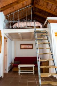 1 cama elevada con escalera en una habitación en Apartamentos Hacienda Sajorami, en Zahora