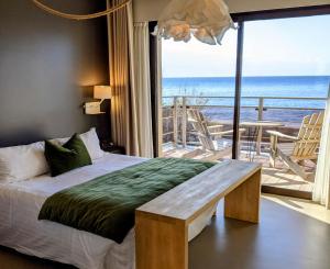 een slaapkamer met een bed en uitzicht op de oceaan bij Hotel Plein Large in Bandol