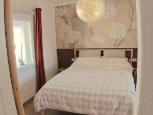 a bedroom with a bed and a chandelier at Hideaway Galicia Corrubedo in Corrubedo
