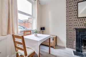 ein Esszimmer mit einem Tisch und einem Kamin in der Unterkunft Beautiful 2 Bed House, South Belfast. 7 Minutes city centre. in Belfast