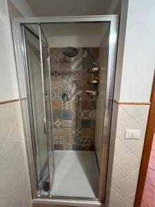 um chuveiro com uma porta de vidro na casa de banho em Appartamento Galgani em San Vincenzo