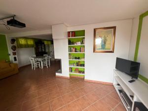 uma sala de estar com televisão e uma sala de jantar em Appartamento Galgani em San Vincenzo