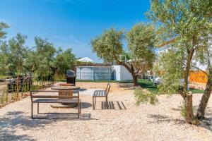 einen Park mit einer Bank, einem Tisch und Stühlen in der Unterkunft Casita Los Garranchos in Córdoba