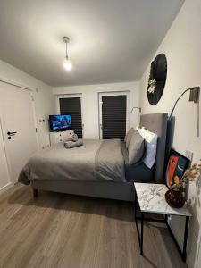 1 dormitorio con 1 cama grande y 1 sofá en Beckenham- PRIVATE DOUBLE Bedroom With En-suite in SHARED APARTMENT, en Elmers End