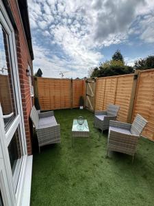 a patio with chairs and a table and a fence at Quite and comfortable Eastbourne in Eastbourne