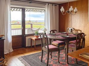 ein Esszimmer mit einem Tisch, Stühlen und einem Fenster in der Unterkunft Holiday home LAHOLM XIII in Laholm