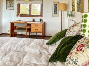 Schlafzimmer mit einem Schreibtisch und einem Bett in der Unterkunft Holiday home LAHOLM XIII in Laholm