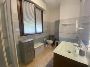 a bathroom with a sink and a toilet and a window at Casetta Tommaso in Porto Ercole +20 photos