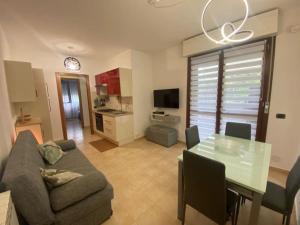a living room with a couch and a glass table at Casetta Tommaso in Porto Ercole