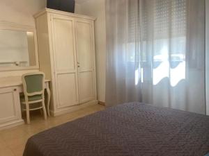 a bedroom with a bed and a desk and a window at Casetta Tommaso in Porto Ercole