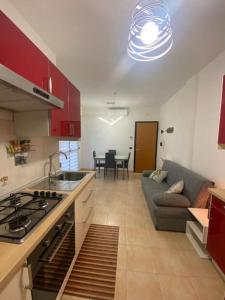 a kitchen and living room with a couch and a stove at Casetta Tommaso in Porto Ercole