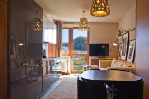 Il comprend une cuisine et un salon avec une table et un canapé. dans l'établissement Aba Apartamenty, à Krynica-Zdrój