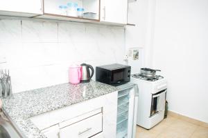 a kitchen with a counter with a microwave and a stove at House of L in Eldoret