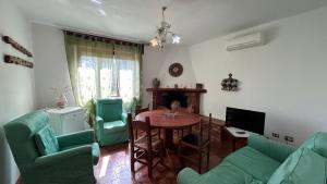 uma sala de estar com uma mesa e cadeiras verdes em Villa Matteo San Teodoro em San Teodoro