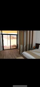 瓦迪拉姆的住宿－Wadi Rum sky Camp，一间卧室设有两张床和大窗户