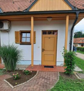 摩拉瓦托普利采的住宿－Apartma Trobentica 23，砖砌庭院上一扇黄色门的房子