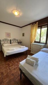 um quarto com 2 camas e uma janela em Villa Matteo San Teodoro em San Teodoro