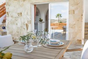 a wooden table with plates and vases on it at Casa Verano - Moraira in Moraira