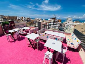 d'un balcon sur le toit avec des tables et des chaises. dans l'établissement We Street Hostel - El Arenal-Albergue juvenil, à El Arenal