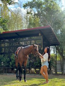 une femme pèche un cheval dans un champ dans l'établissement OFF THE GRID - Imagined adventures in a relaxing escape, à Alfonso